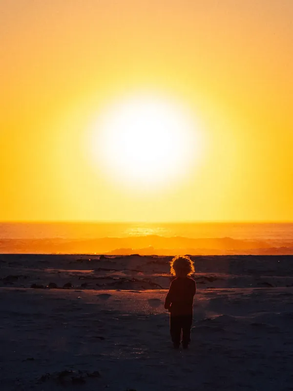 A child watching the sun go down over the sea